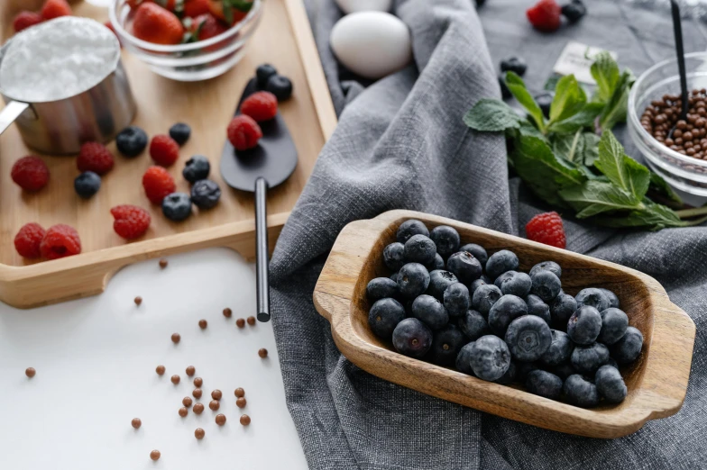 a wooden bowl filled with fresh blueberries