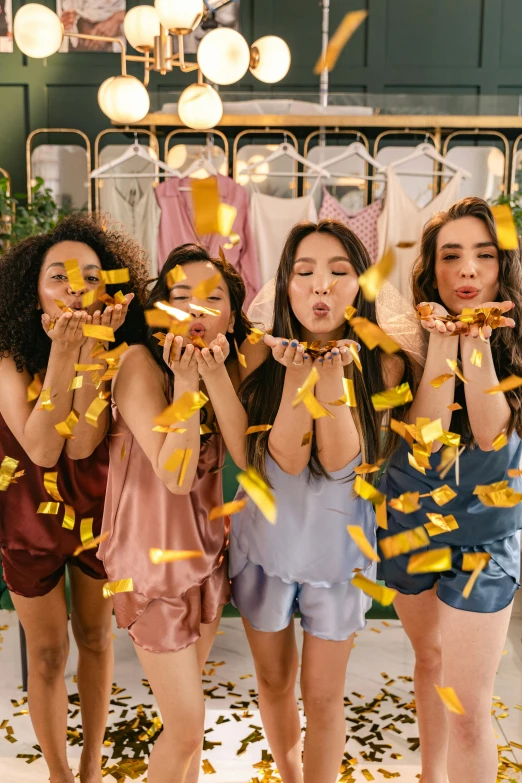 a group of ladies holding onto yellow confetti