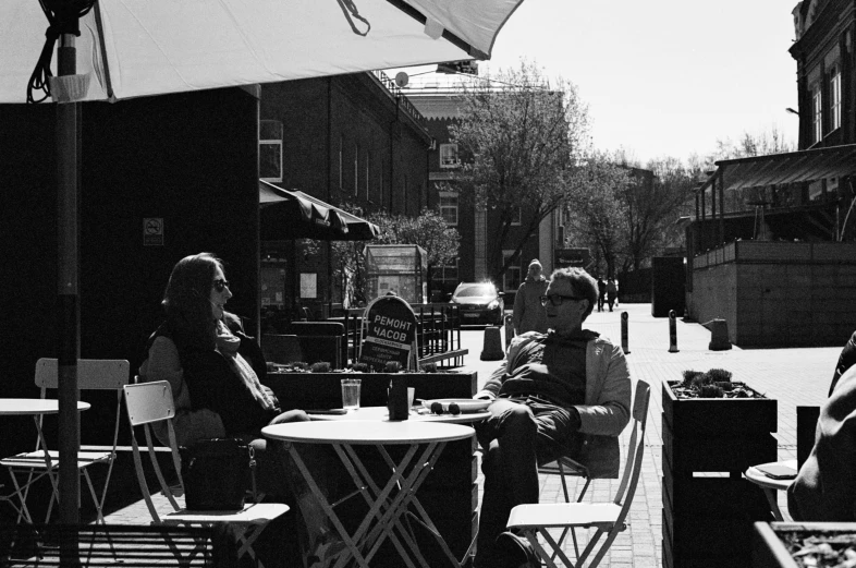 a woman and man are eating at an outdoor restaurant