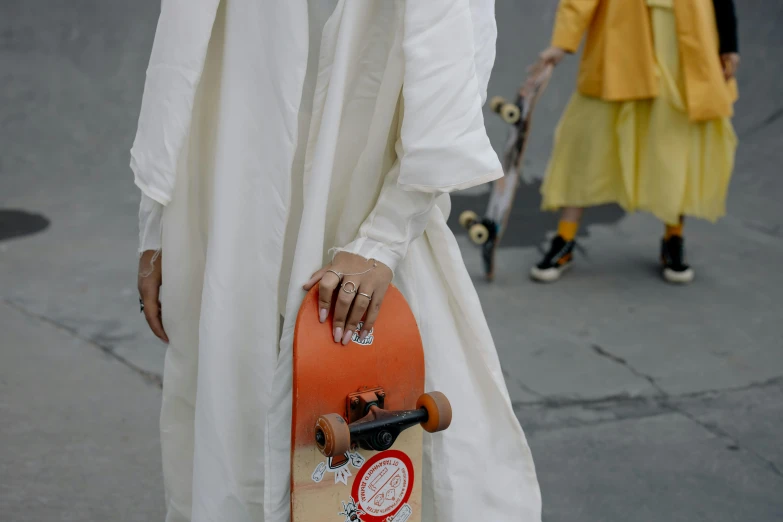 a girl in white is holding a skateboard