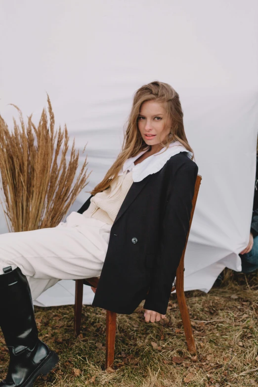 a woman sitting on top of a wooden chair