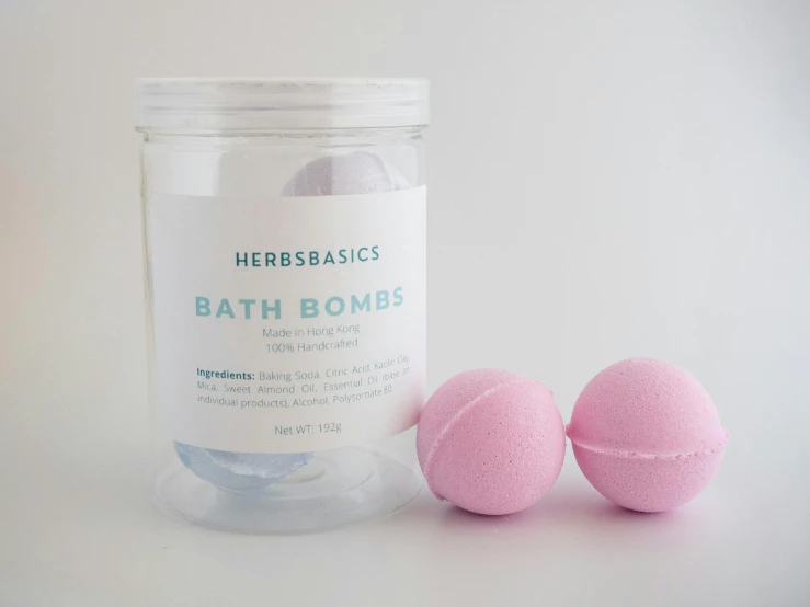 two bath bombs sitting next to a clear jar