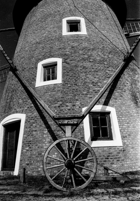 the windmill is in front of a large brick building