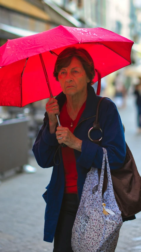 woman walking with umbrella on busy street during day