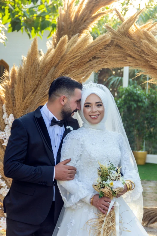 two people are standing under some trees and one is smiling