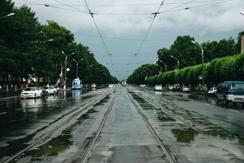 a city street is full of cars parked in the rain