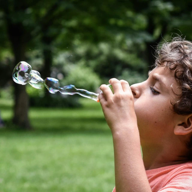 a  blowing bubbles in the park