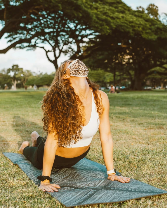 a woman sits on her yoga mat, stretching