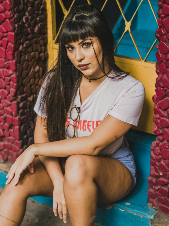 a woman sitting on the steps in front of a red and blue door