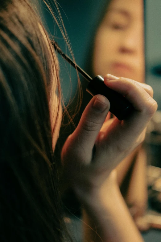 a woman that is putting some kind of thread in her hair