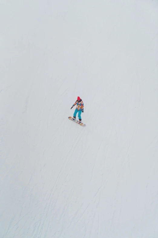 the person in the blue snow suit is skiing down a hill