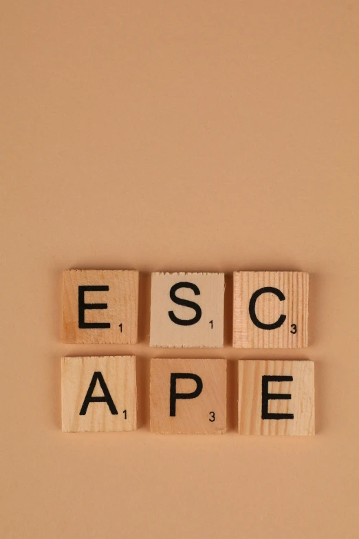 wood blocks that spell out escape on a tan background