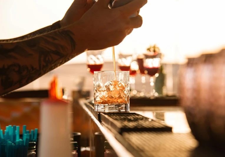 bartenders have their hands holding a tray of glasses of liquid