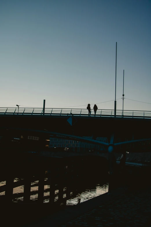 a bridge with two people standing on the other side of it