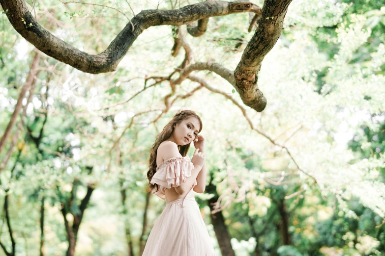 a woman standing in the forest with her hands in her ears