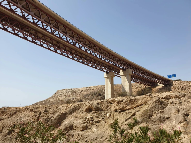 two road beams going under a metal bridge