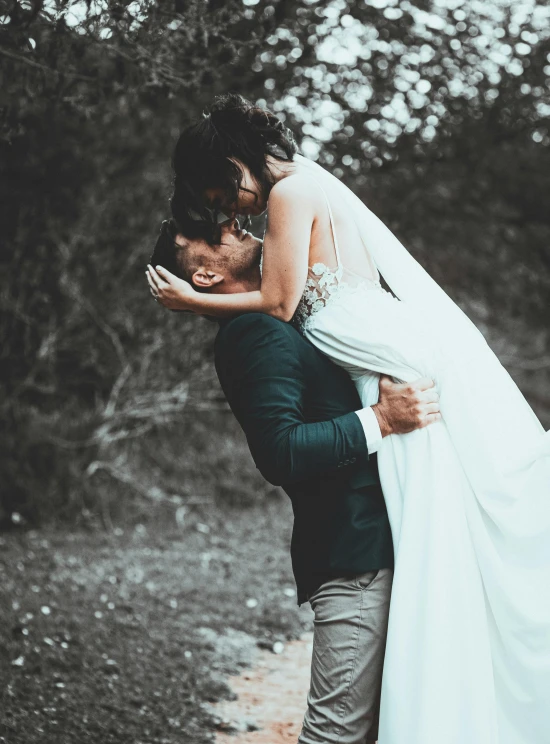 a woman hugs the man who is wearing a wedding dress