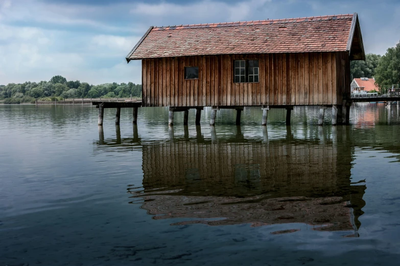 a house sits on stilts across from the water