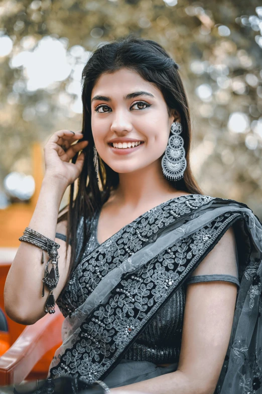 a young woman wearing an ethnic outfit with a beaded around her neck