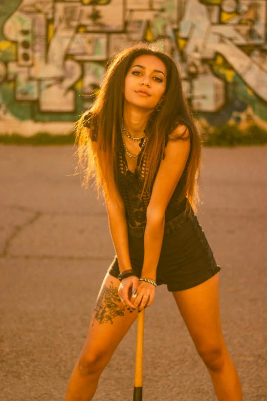 a young woman in shorts holding a baseball bat