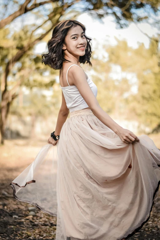 an older woman smiles as she stands outdoors in a dress