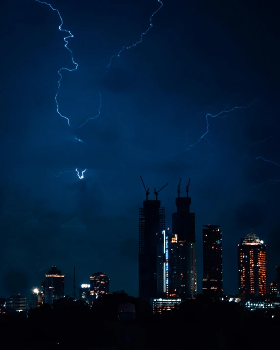 a city skyline with clouds and lightning in the distance