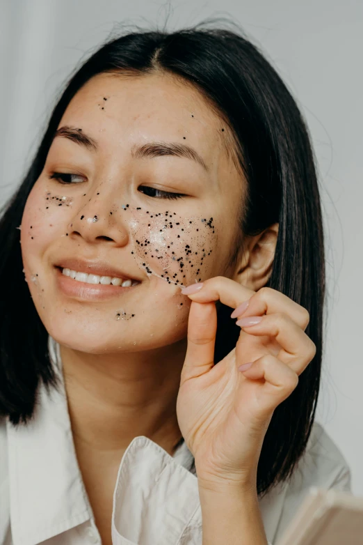 an asian woman with lots of black dots on her face