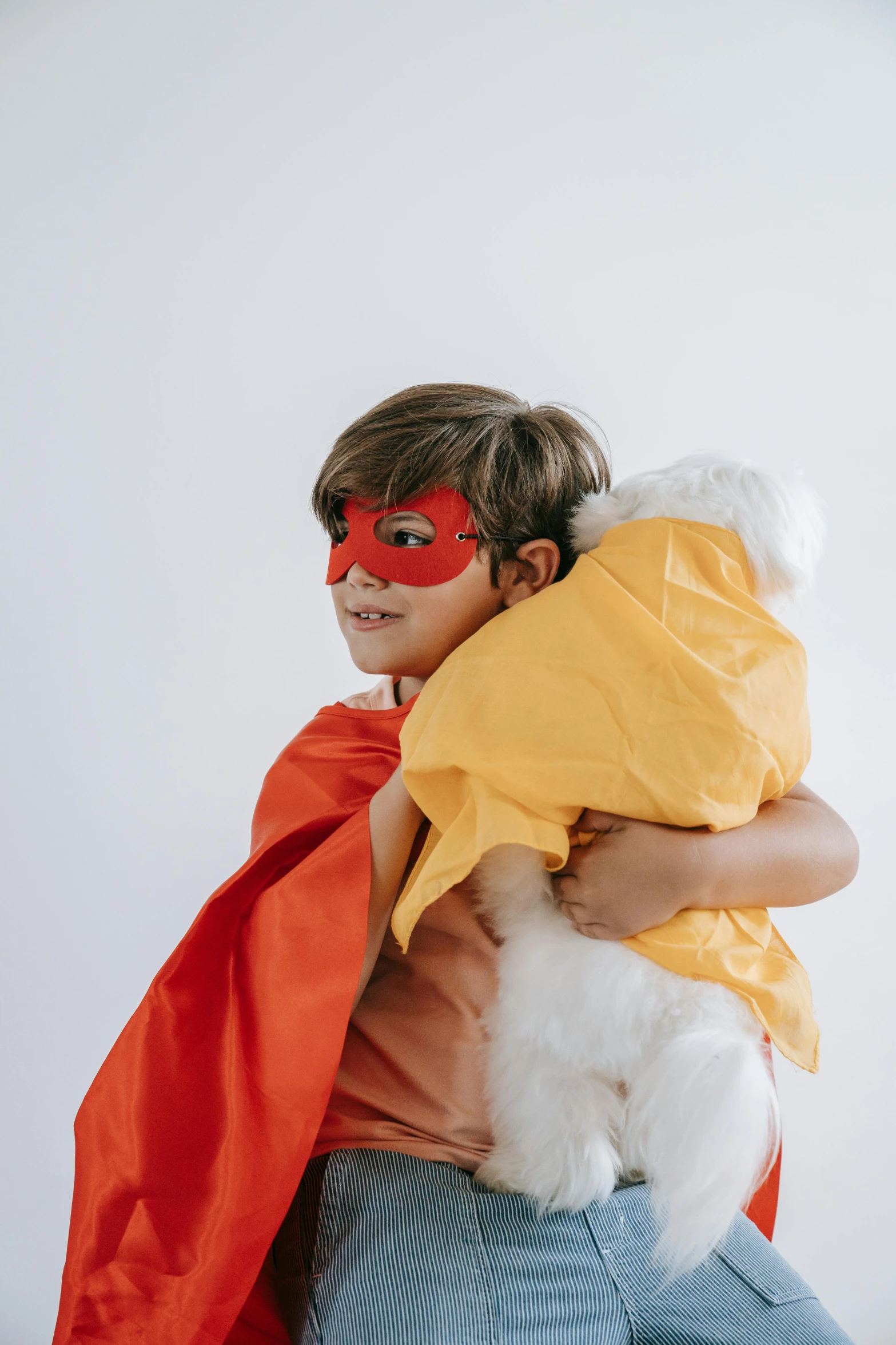 a  in a red mask holding a stuffed toy