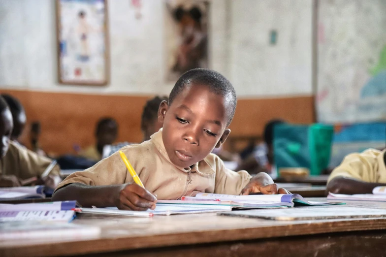 two small children sitting at a desk working