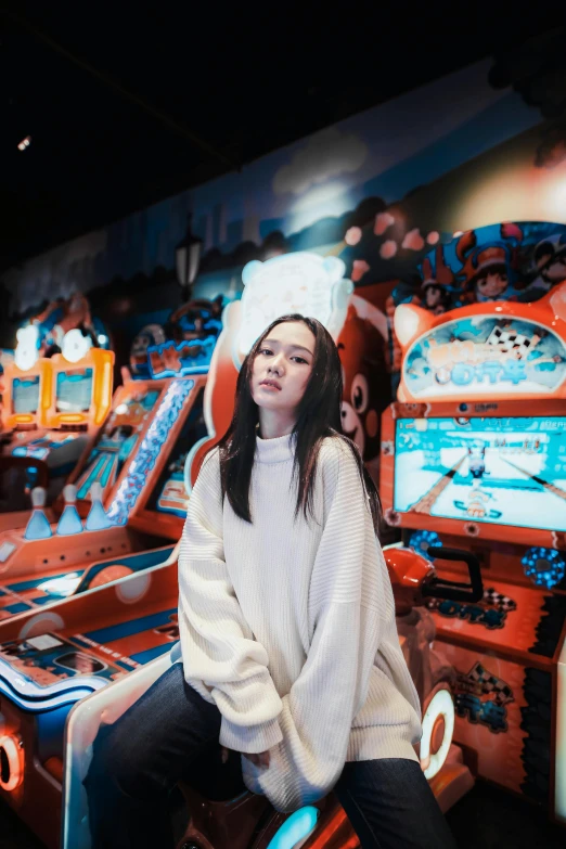 a woman poses for a picture in front of pinball games