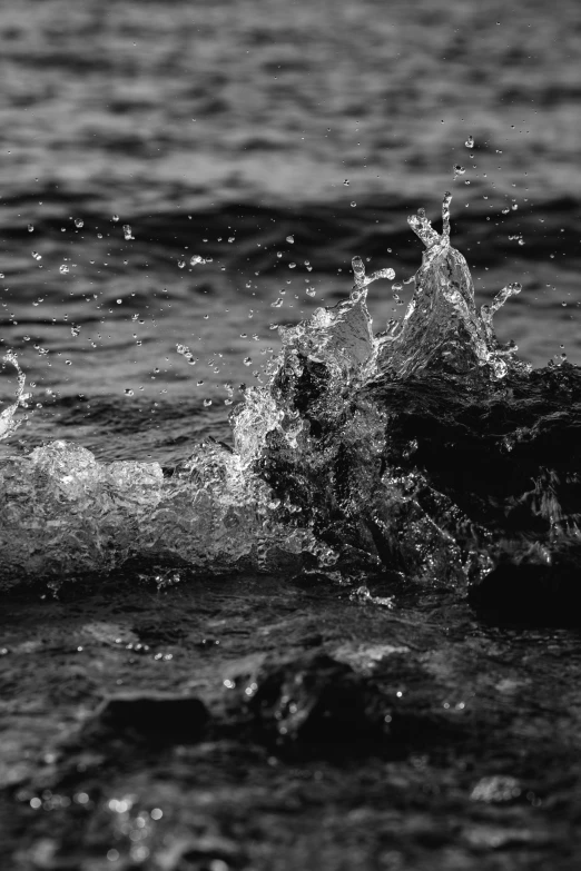 black and white po of water splashing out of the ocean