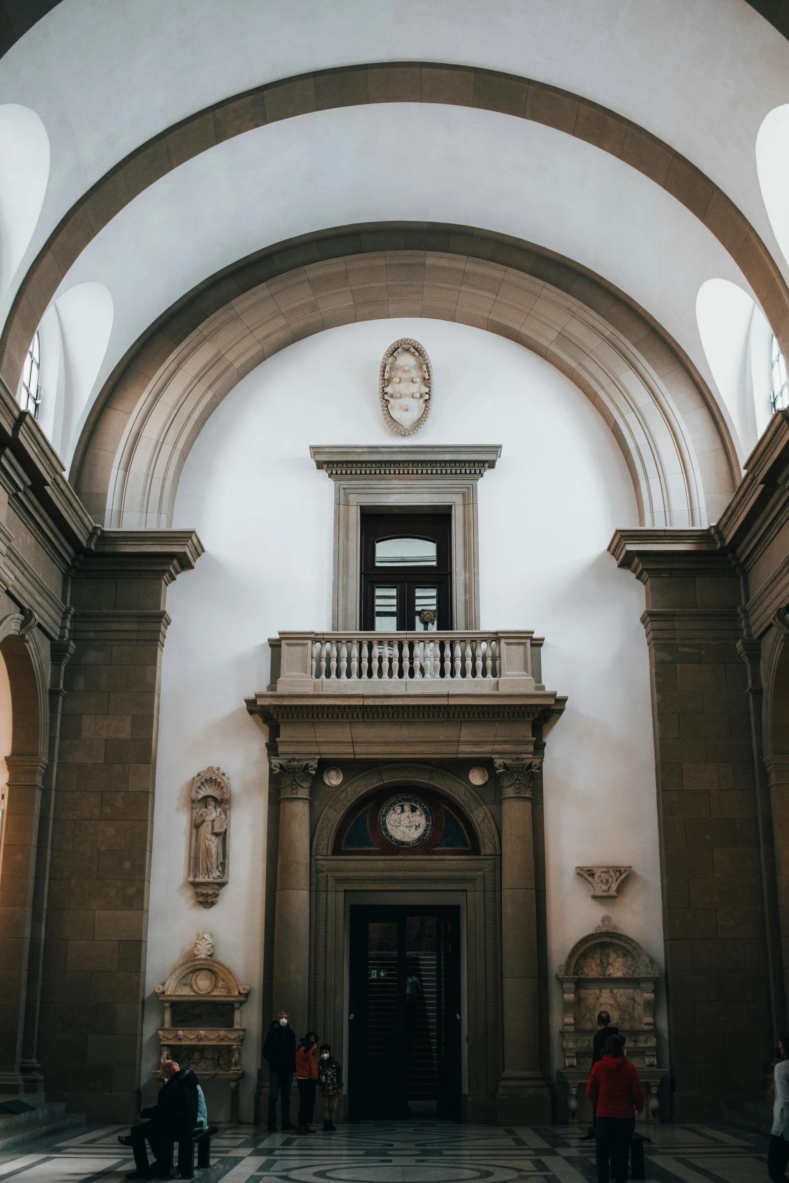 a building with a large arched ceiling, two stories above and an exit to another room below