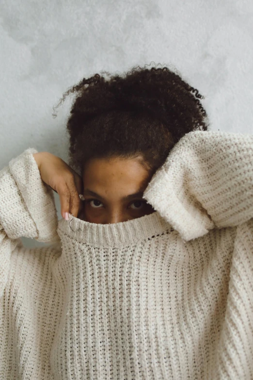 a person wearing a white sweater looking over their shoulder