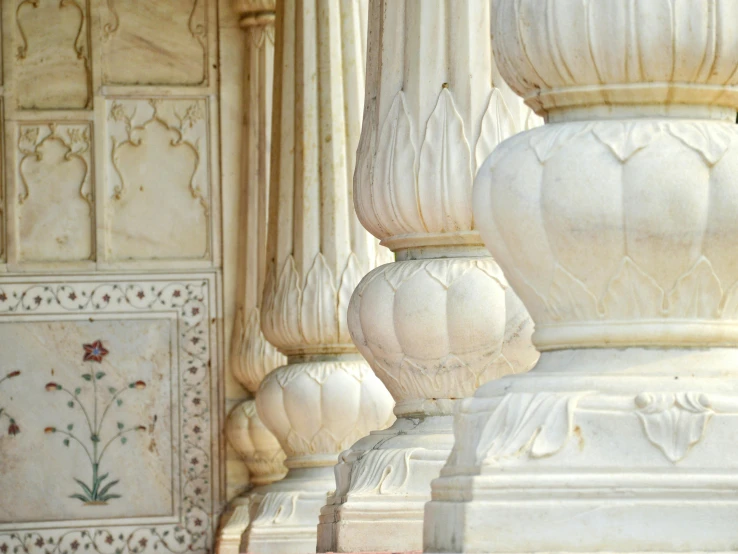 large white stone pillars are stacked up in front of the wall