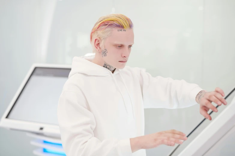 man in a white outfit standing over some electronics