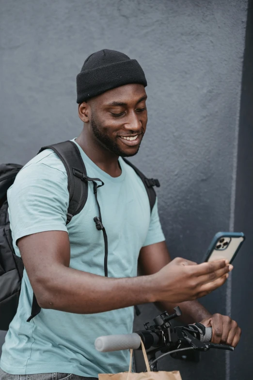 a man smiling while holding a camera and using a phone