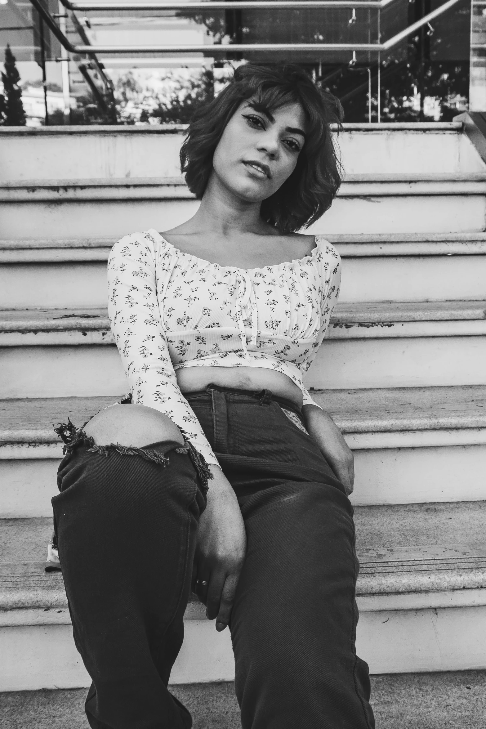 a young woman is sitting on the stairs of steps