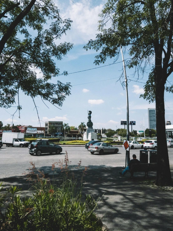 an intersection in front of a town has cars and a traffic light