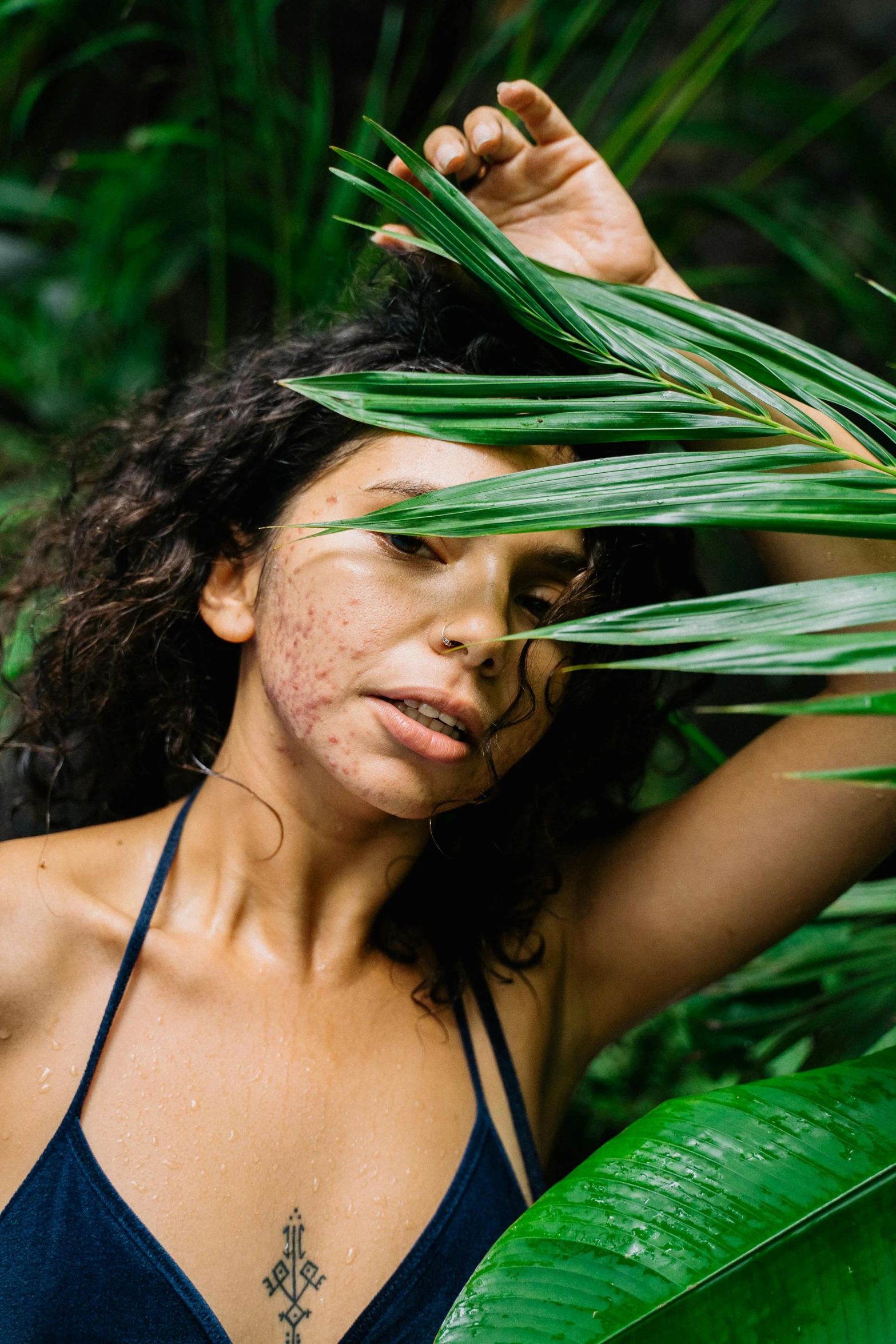 a beautiful woman standing in front of a bush