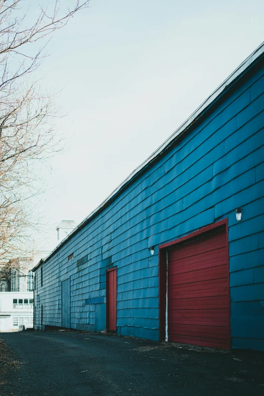 the side of a building with two garages is red and blue