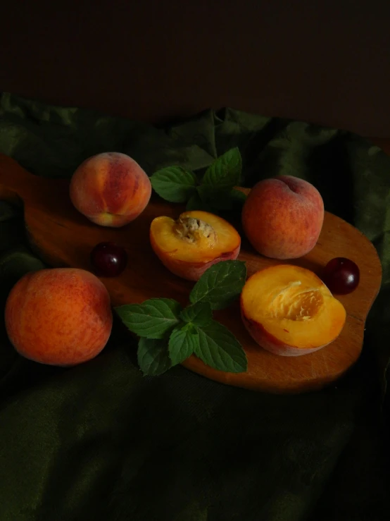 peaches and plums on a wood tray with leaves