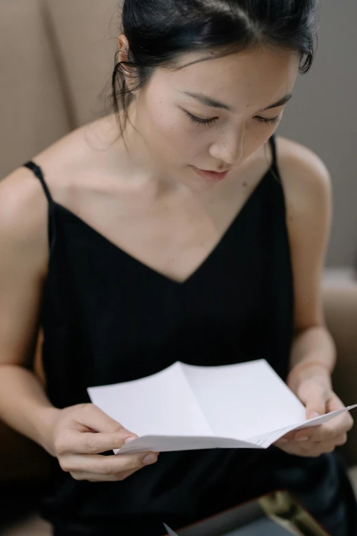 woman holding open a white piece of paper in her hands