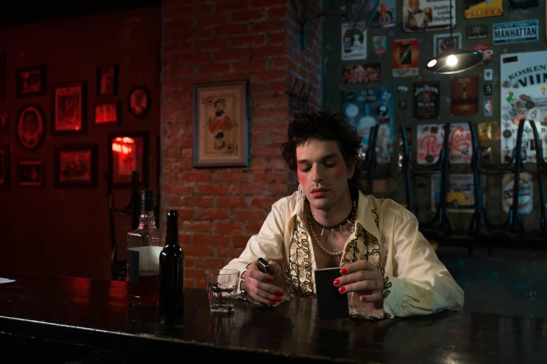 a man in a restaurant setting looking at his cell phone