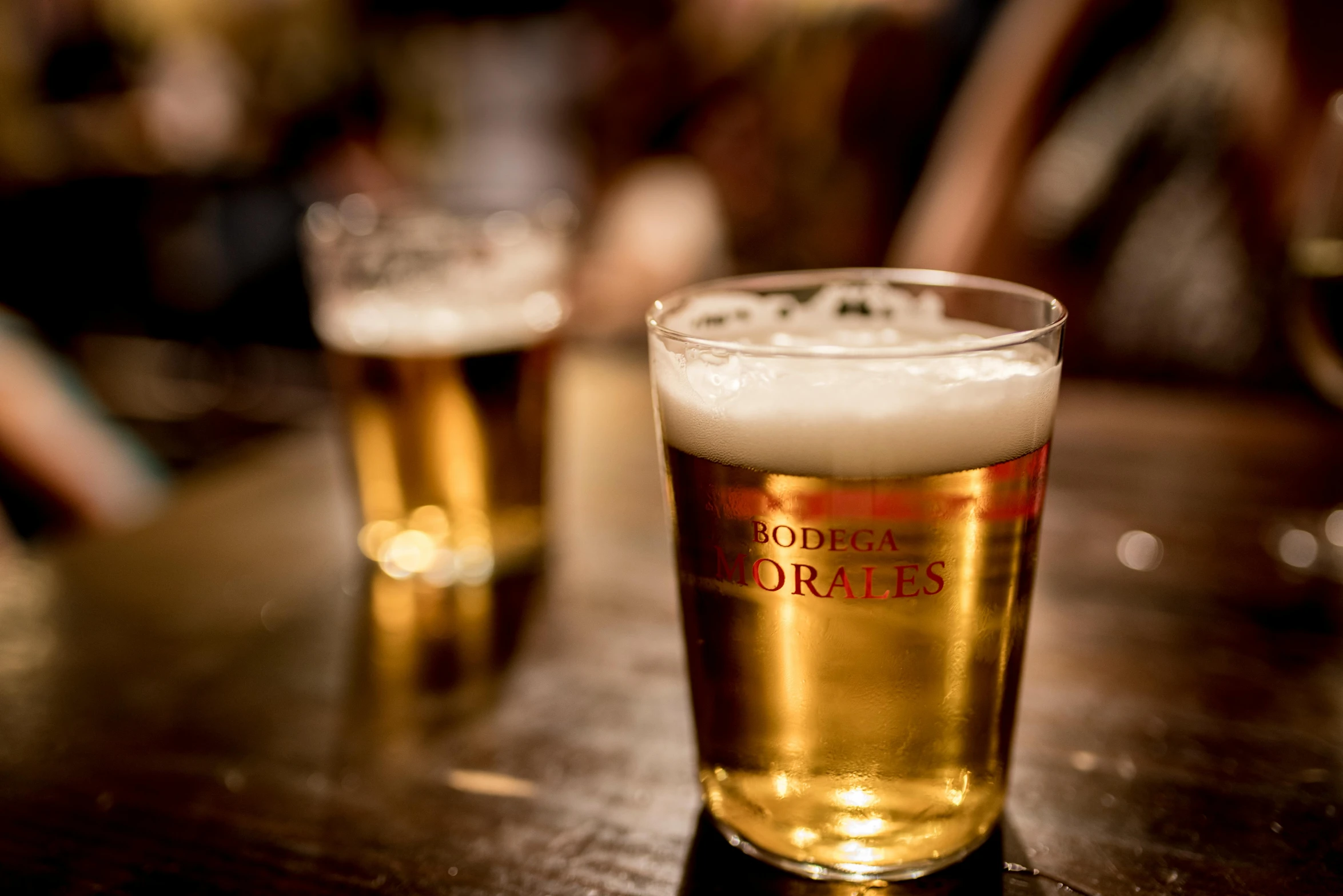 two tall glass mugs are sitting on the bar