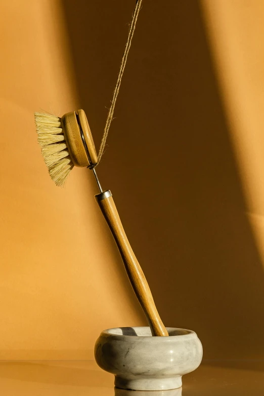 an odd shaped ceramic brush sits in a vase