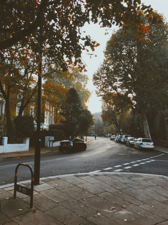 a city street is shown with many cars parked at the curb