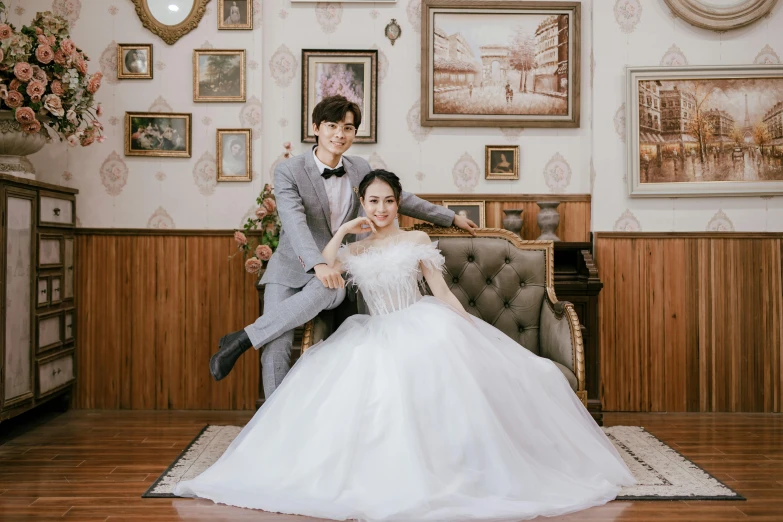 a young married couple posing in front of a wall