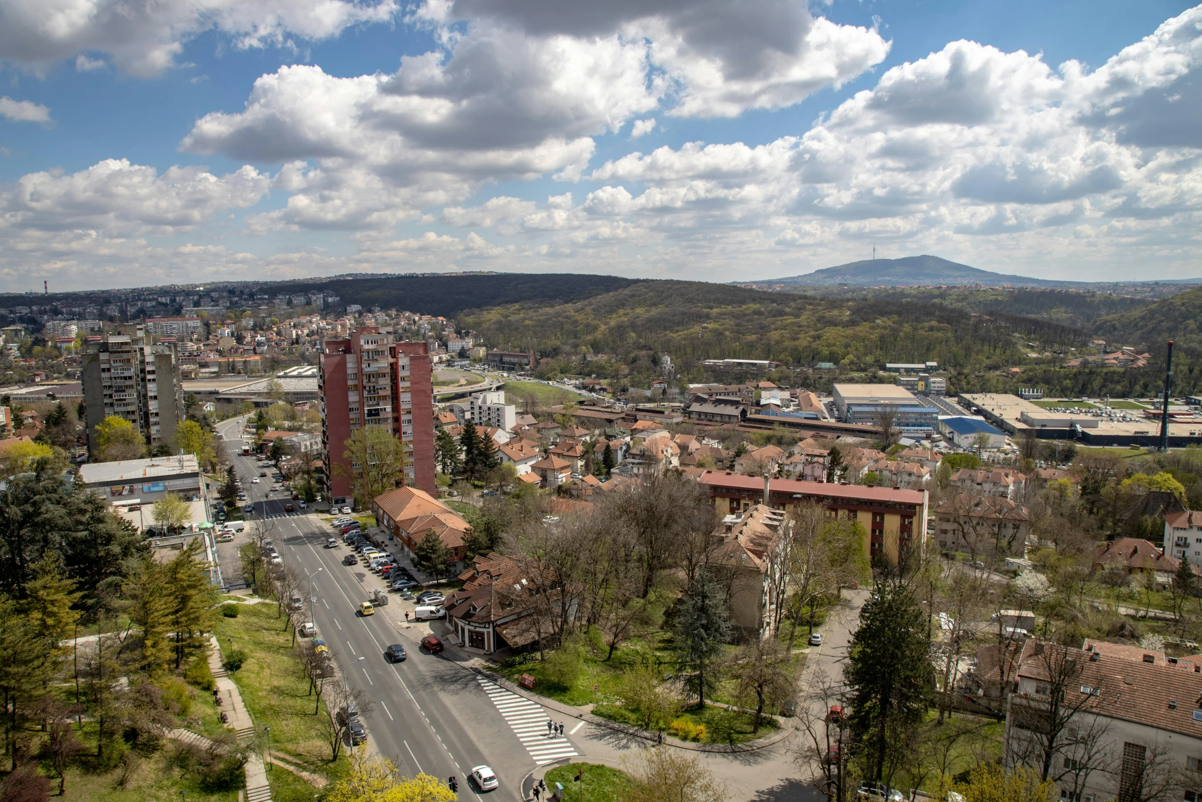 an image of a city with mountains and trees