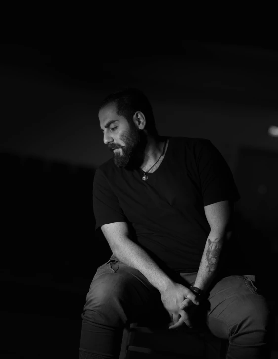 black and white pograph of man with beard sitting in a chair