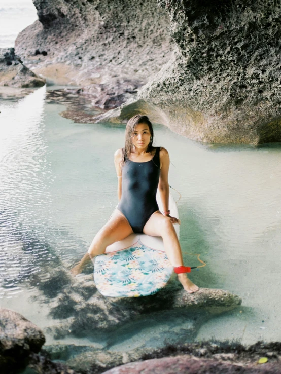 a woman posing on a surfboard in the water